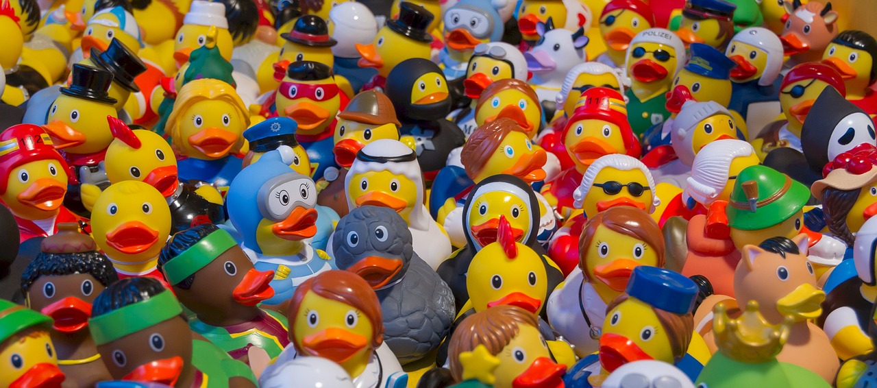 Une foule de canards en plastique jaune, tous avec des tenues différentes